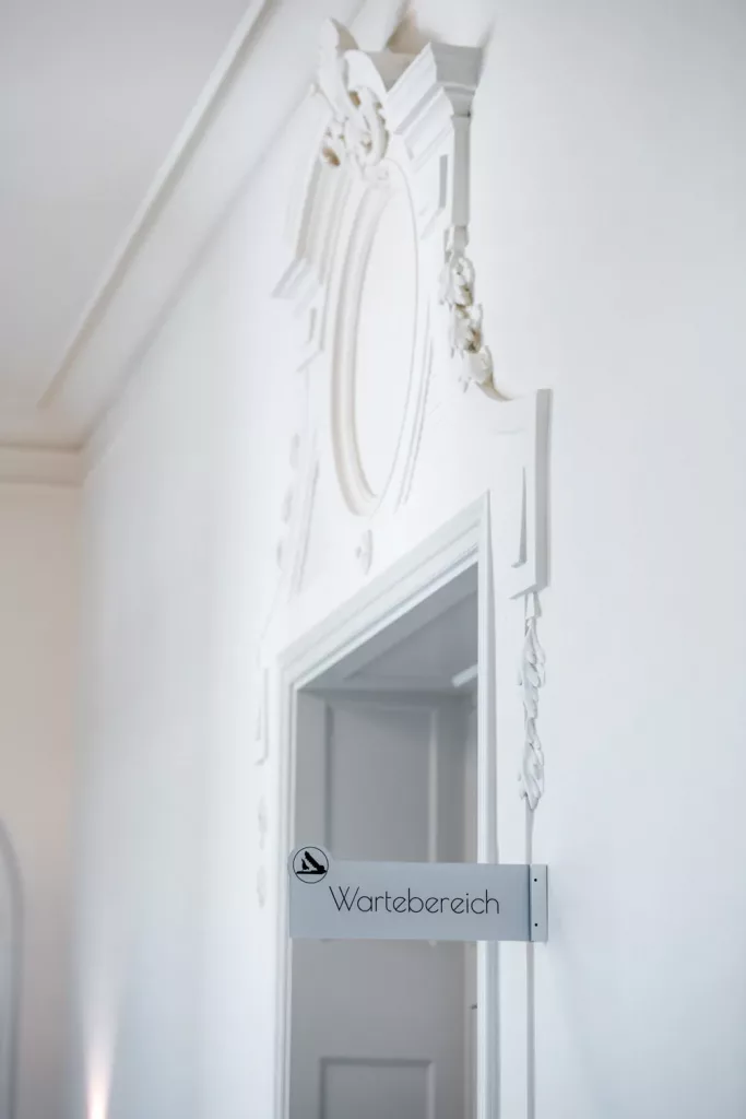 Loepraxis Dr Wilamowskiweb024 Dr Matthias Willamowski Kollegen Ornate white interior doorway with decorative molding and a sign reading Wartebereich waiting area on the door frame