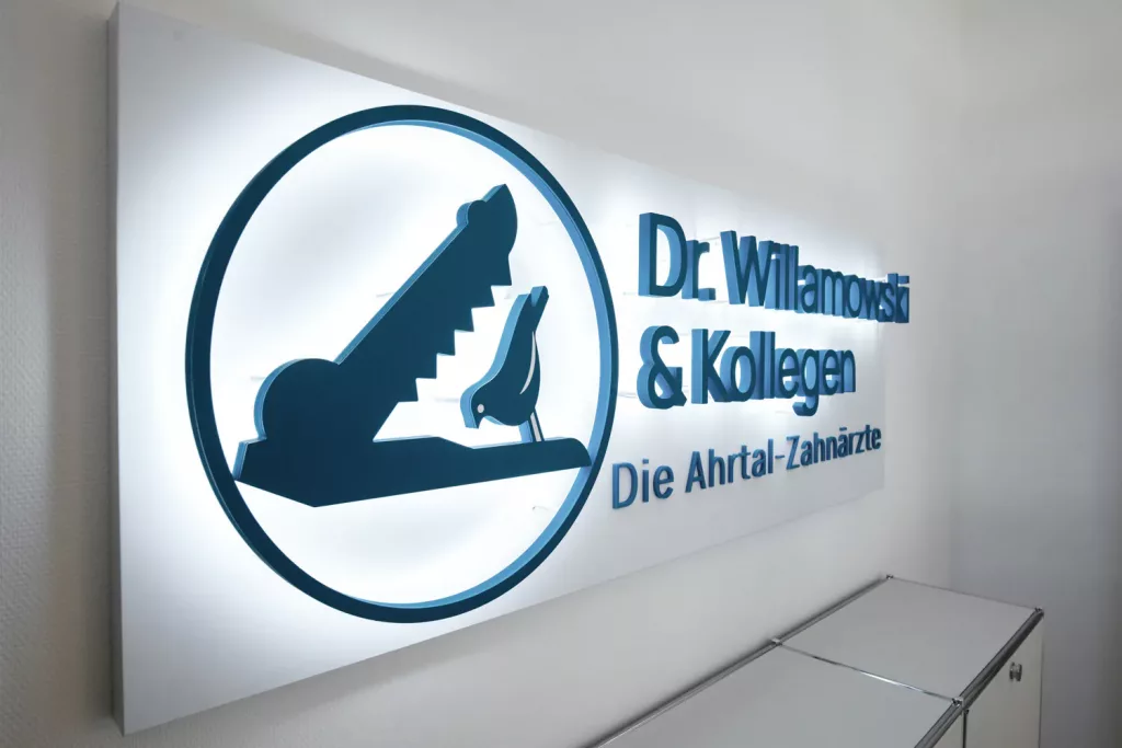 Loepraxis Dr Wilamowskiweb049 Dr Matthias Willamowski Kollegen Wall sign for a dental practice Dr Willamowski Kollegen Die Ahrtal Zahnarzte with a blue circular logo of a tooth inside a circle to the left