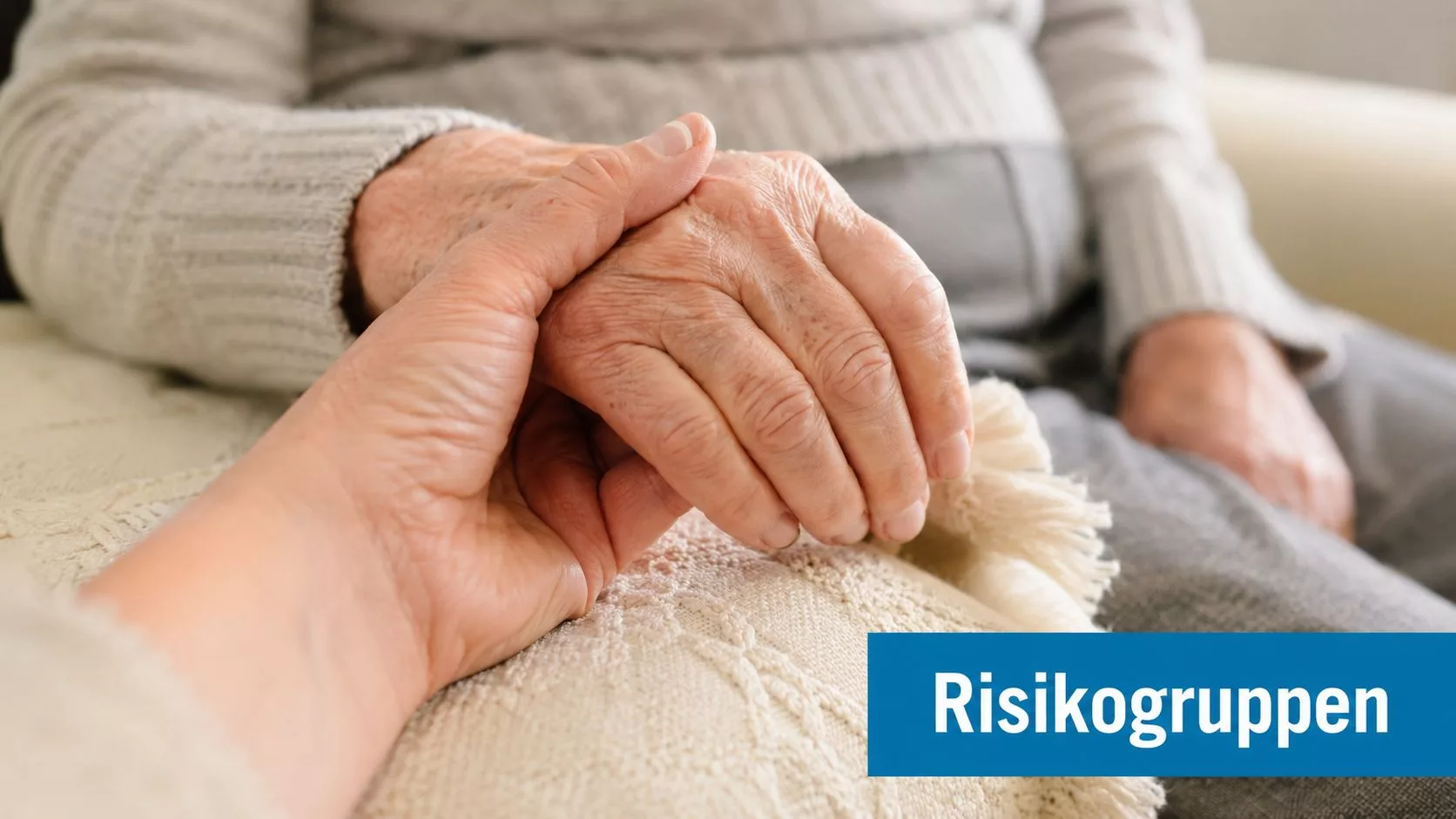 Eine jüngere Person hält liebevoll die faltige Hand einer älteren Person zur Unterstützung und emotionalen Zuwendung.